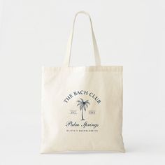 the beach club palm springs tote bag is shown in white and has a palm tree on it