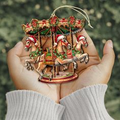 a person holding up a christmas ornament in their hands