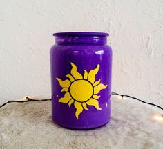 a purple jar with yellow sun painted on it