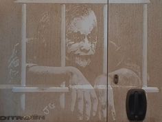 an image of a man behind bars painted on the side of a building