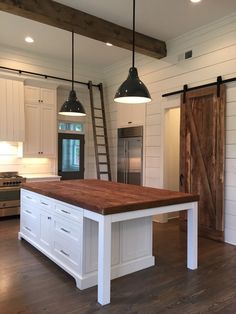 a kitchen with an island and two lights hanging from the ceiling