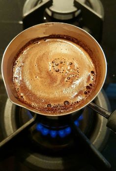 a cup of coffee sitting on top of a stove