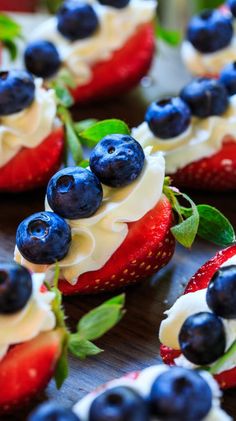 strawberries and blueberries are arranged on top of each other with white frosting