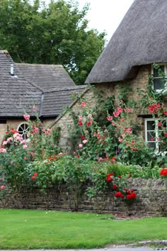 an old stone house with roses growing on it