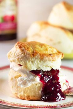 a biscuit with jam and cream on a plate