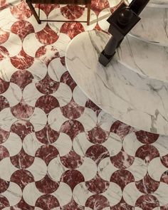 a bathroom with red and white tiles on the floor