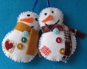 two snowmen are hanging on a blue background