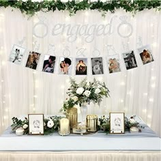 a table topped with pictures and flowers under a banner