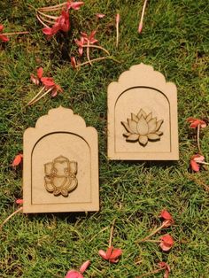 two wooden plaques sitting on top of a lush green field