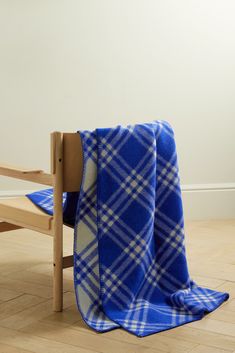 a blue and white blanket sitting on top of a wooden chair