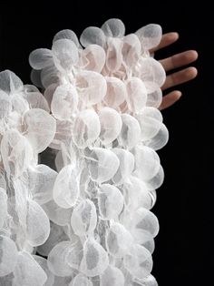 a person's hand is touching some white plastic balls