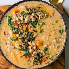 a bowl filled with soup sitting on top of a wooden cutting board