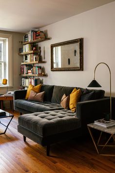 a living room filled with furniture and bookshelves next to a wooden flooring