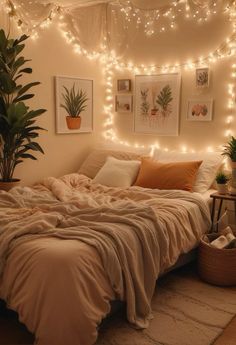 an unmade bed with blankets and lights on the wall above it, surrounded by potted plants