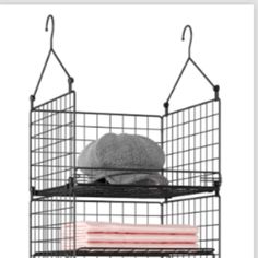 a black wire shelf with a stuffed animal in it