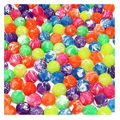 many different colored candies on a white surface