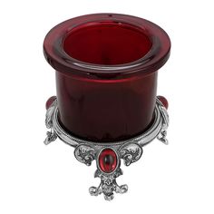 a red glass candle holder sitting on top of a table