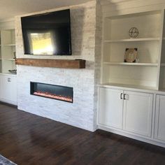 an empty living room with a fireplace and entertainment center