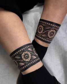 a person with two tattoos on their legs and one has a flower tattoo on her arm