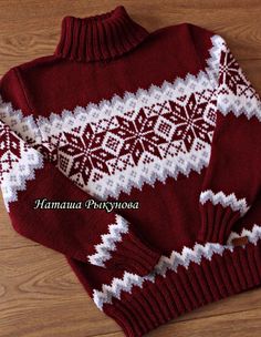 a red and white sweater sitting on top of a wooden floor