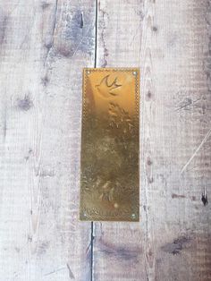 an old brass plate on a wooden surface