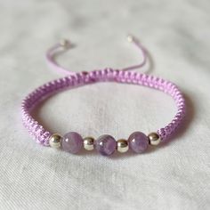 a purple bracelet with three beads on it