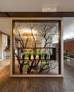 an open glass window with trees and plants in it