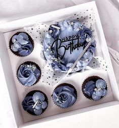 a box filled with blue cupcakes covered in frosting