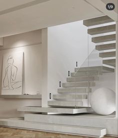 a staircase in a modern home with artwork on the wall