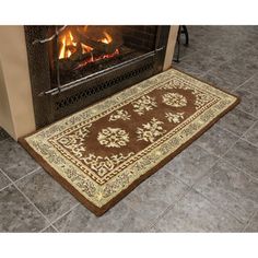 a brown rug sitting on top of a tile floor next to a fire in a fireplace