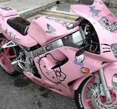 a pink hello kitty motorcycle parked on the street