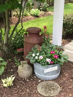 a potted planter with flowers in it next to a mailbox and tree