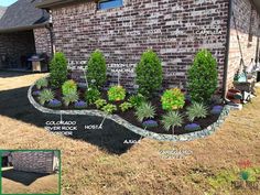 a brick house with landscaping around it and plants in the front yard, along with other landscaping items