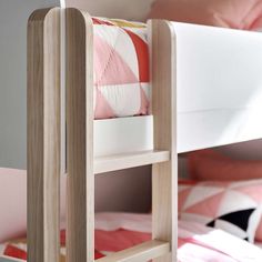 a wooden bunk bed with pink and white bedspread on it's sides