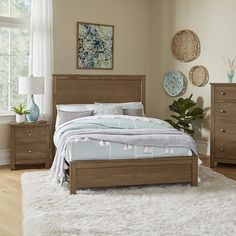 a bedroom scene with focus on the bed and nightstands in the foreground, along with a rug on the floor