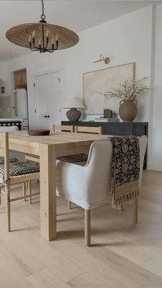 a dining room table with chairs and a chandelier hanging from it's ceiling