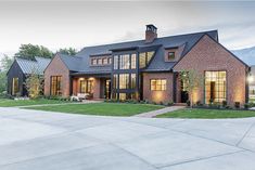 a large brick house with lots of windows on the front and side of it's roof