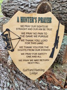 a wooden plaque with an image of a hunter's prayer written on it in front of a tree