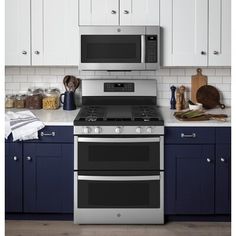 a stove top oven sitting inside of a kitchen next to blue cabinets and counter tops