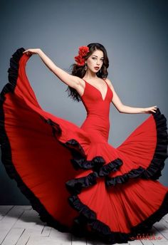 a woman in a red and black dress is posing for a photo with her arms outstretched