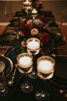 the table is set with candles, plates and glasses for dinner guests to enjoy their meal