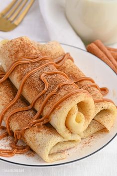 a plate with some food on it next to a cup and saucer filled with cinnamon