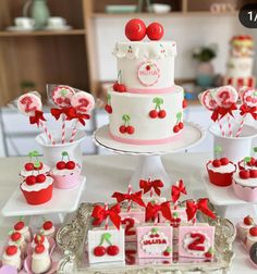 a table topped with cakes and cupcakes covered in frosting