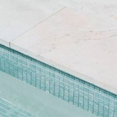 an empty swimming pool next to a tiled wall