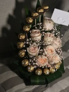 a bouquet of roses and chocolates on a table with a card in the middle