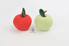 two crocheted apples sitting next to each other