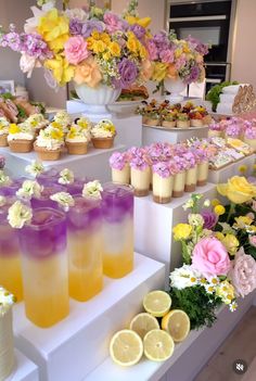 there are many cupcakes on the table with flowers and lemons in them