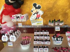 the table is set up with minnie mouse party supplies and balloons for guests to enjoy