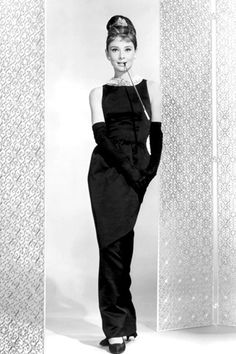 a black and white photo of a woman in an evening dress posing for the camera