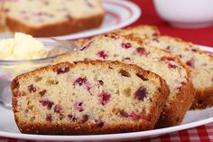 four slices of bread on a plate with butter and strawberries